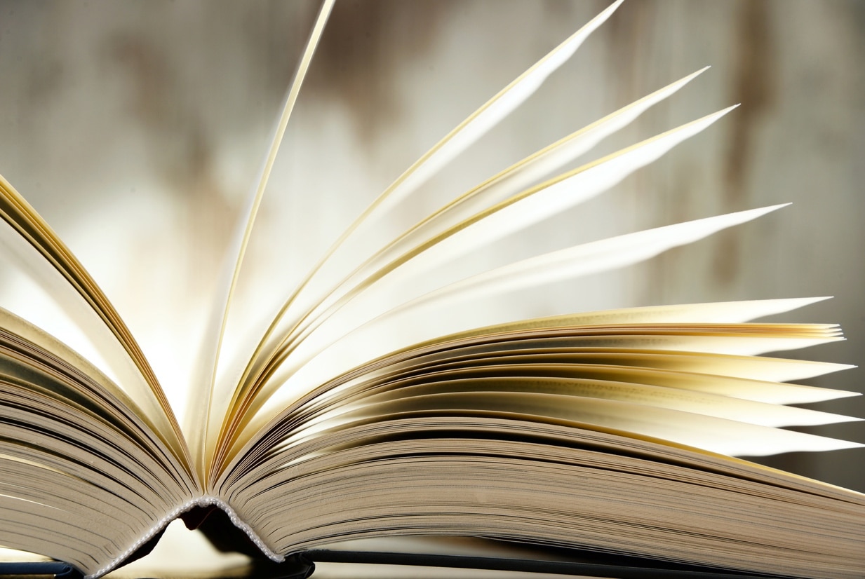 Livre ouvert aux pages dorées feuilletées, façonné par Signum Imprimerie